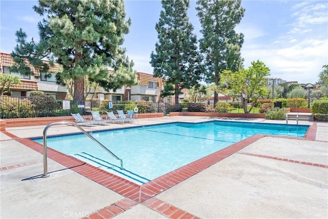 community pool featuring a patio area and fence