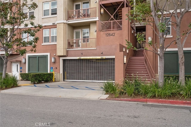 12842 Palm St Unit 301, Garden Grove, CA 92840 - view of front facade featuring an attached garage, concrete driveway, and stucco siding