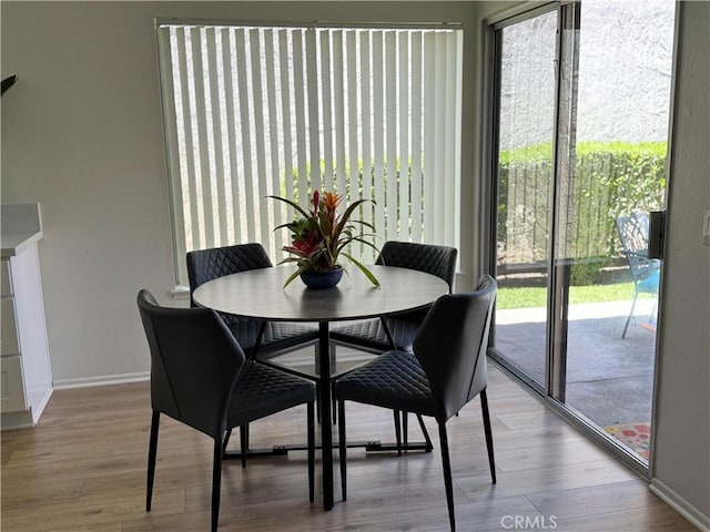 dining area with baseboards and wood finished floors