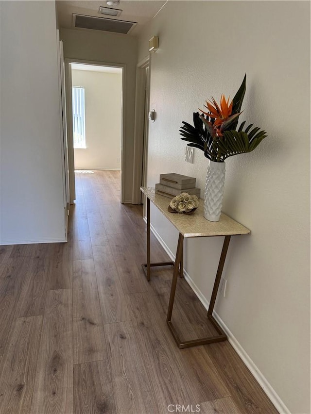hallway featuring baseboards and wood finished floors