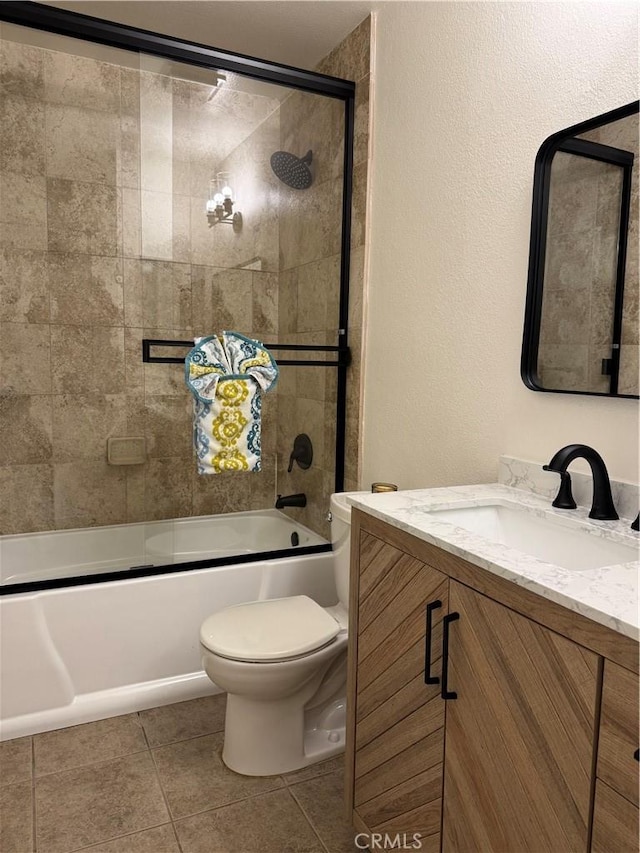 full bath with combined bath / shower with glass door, toilet, tile patterned flooring, and vanity