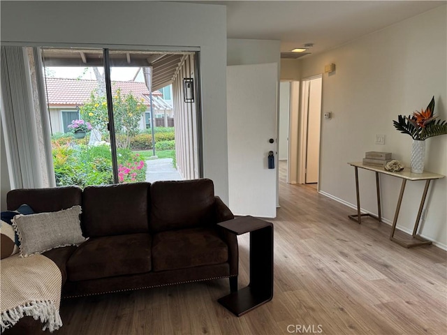 living area featuring light wood-style floors and baseboards