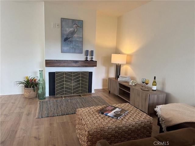 living room with baseboards, a fireplace, and wood finished floors