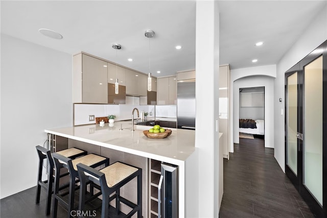 kitchen featuring a breakfast bar area, dark wood-style flooring, wine cooler, modern cabinets, and a peninsula