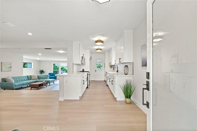347 E Barkley Ave, Orange, CA 92867 - kitchen with light countertops, light wood-style flooring, a wealth of natural light, and white cabinetry