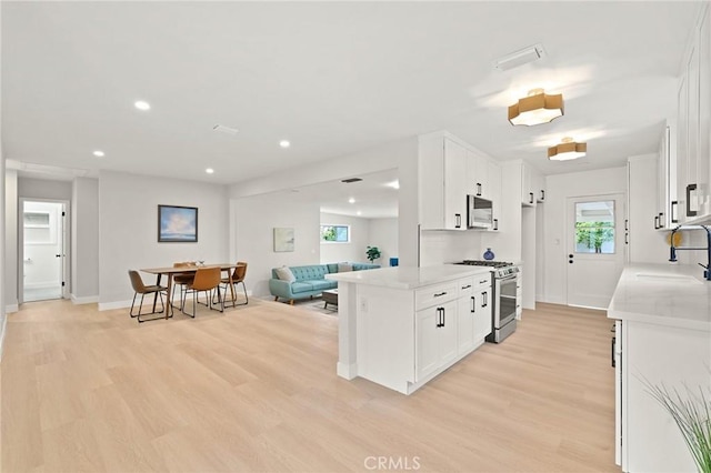 347 E Barkley Ave, Orange, CA 92867 - kitchen with white cabinets, a sink, light wood-style flooring, appliances with stainless steel finishes, and open floor plan