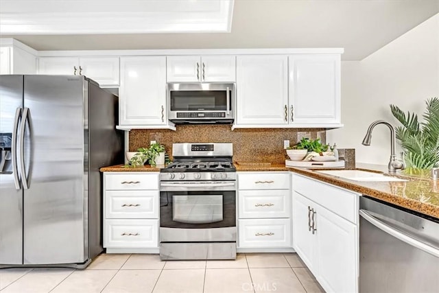 86 Sandpiper Unit 17, Irvine, CA 92604 - kitchen featuring stainless steel appliances, a sink, light tile patterned flooring, white cabinetry, and decorative backsplash