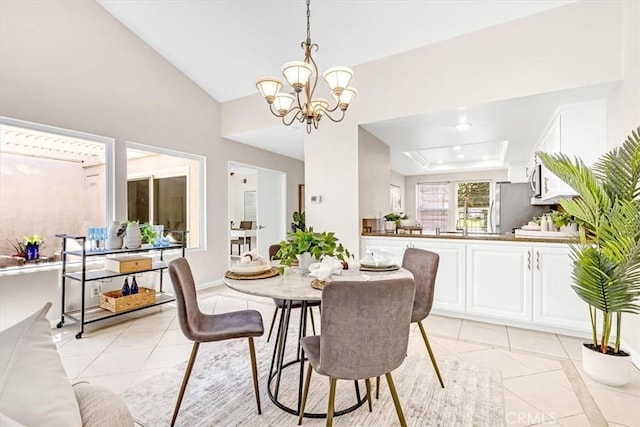 86 Sandpiper Unit 17, Irvine, CA 92604 - dining area with lofted ceiling, a notable chandelier, a tray ceiling, and light tile patterned floors