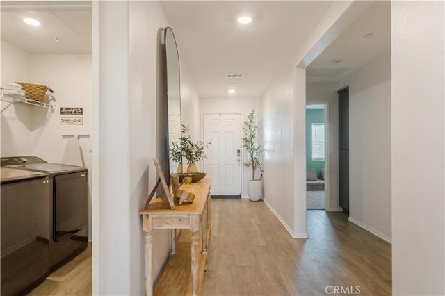 corridor featuring recessed lighting, separate washer and dryer, visible vents, baseboards, and wood finished floors