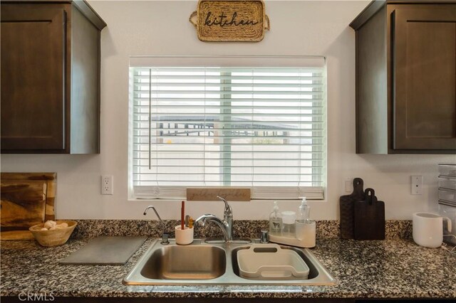 kitchen featuring dark brown cabinetry and a sink