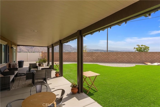 view of patio / terrace with a mountain view, an outdoor hangout area, and a fenced backyard