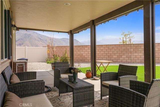 view of patio featuring a mountain view, an outdoor hangout area, and a fenced backyard