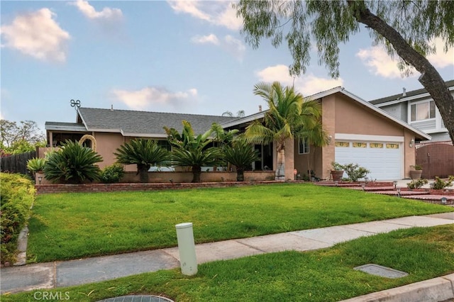 view of front of home with a garage, a front lawn, stucco siding, and fence