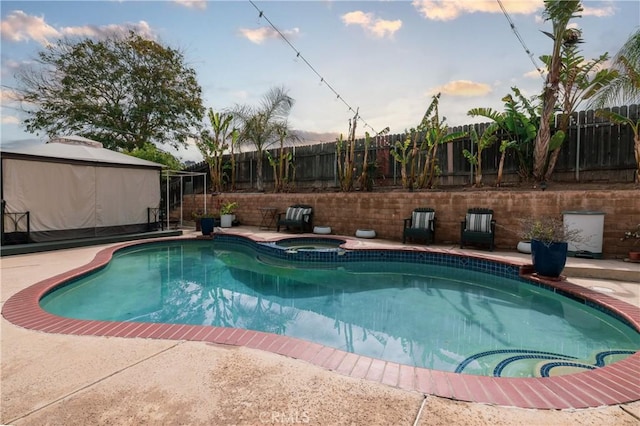 view of swimming pool featuring a fenced backyard, a gazebo, and a pool with connected hot tub