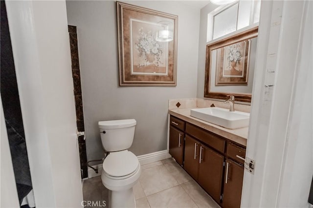 bathroom featuring tile patterned flooring, toilet, vanity, and baseboards