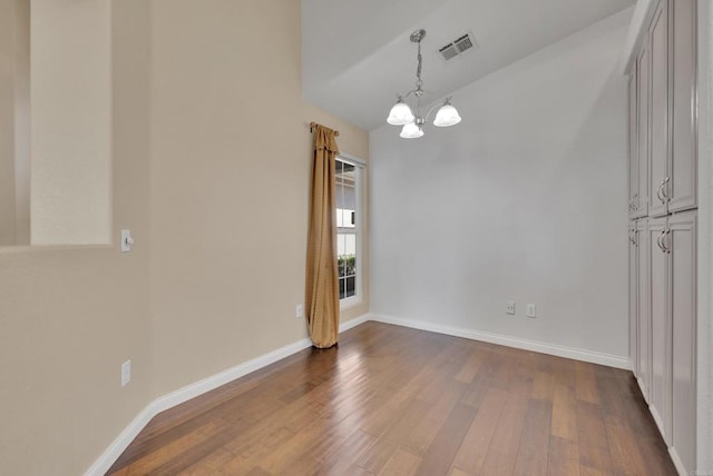unfurnished dining area featuring visible vents, baseboards, dark wood-type flooring, and a chandelier