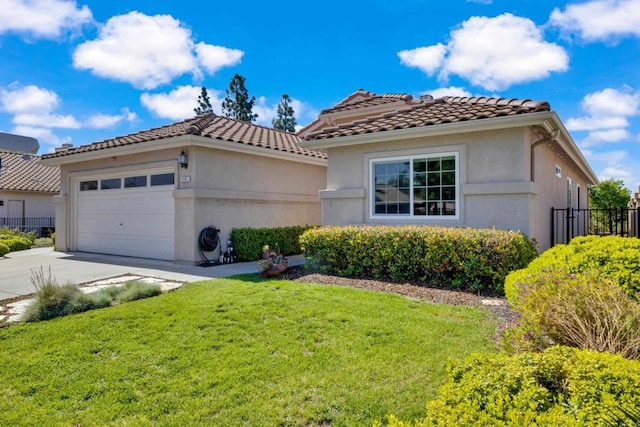 mediterranean / spanish house featuring a tile roof, a front yard, a garage, fence, and concrete driveway