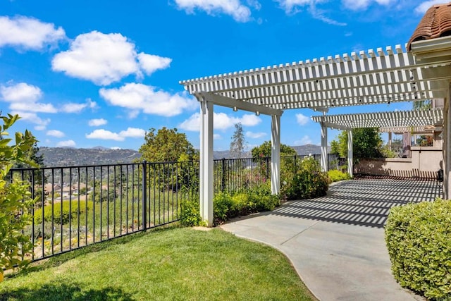 view of yard featuring a patio, a pergola, a mountain view, and a fenced backyard