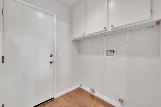 washroom featuring cabinet space, hookup for a washing machine, gas dryer hookup, baseboards, and wood finished floors
