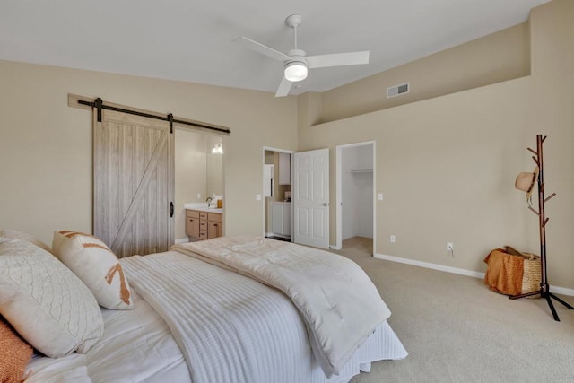 bedroom featuring a barn door, light carpet, baseboards, vaulted ceiling, and visible vents