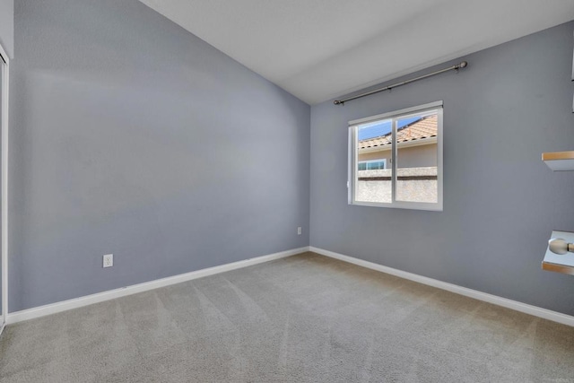 empty room featuring baseboards, vaulted ceiling, and carpet flooring