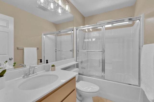 full bath with vanity, enclosed tub / shower combo, tile patterned floors, and toilet