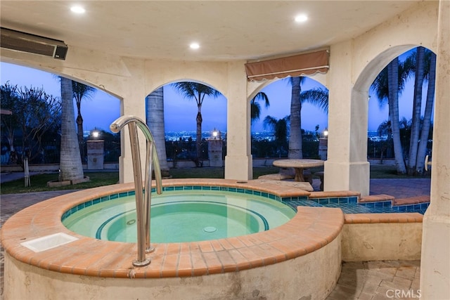 pool at twilight with an in ground hot tub