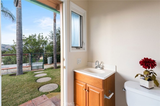 half bathroom featuring a wealth of natural light, toilet, and vanity