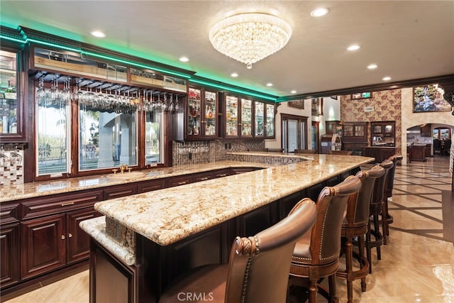 bar featuring arched walkways, backsplash, wet bar, and recessed lighting