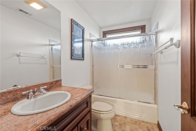 bathroom with visible vents, toilet, enclosed tub / shower combo, and vanity
