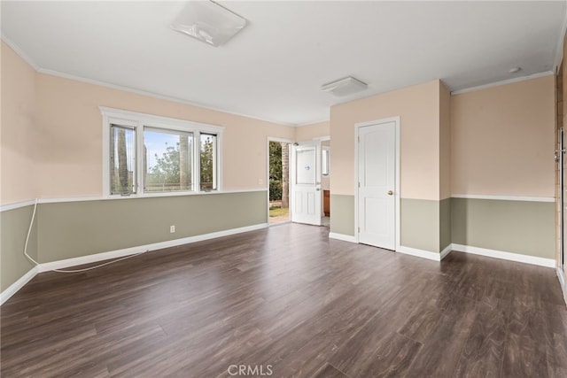 spare room with baseboards, dark wood-style floors, and crown molding