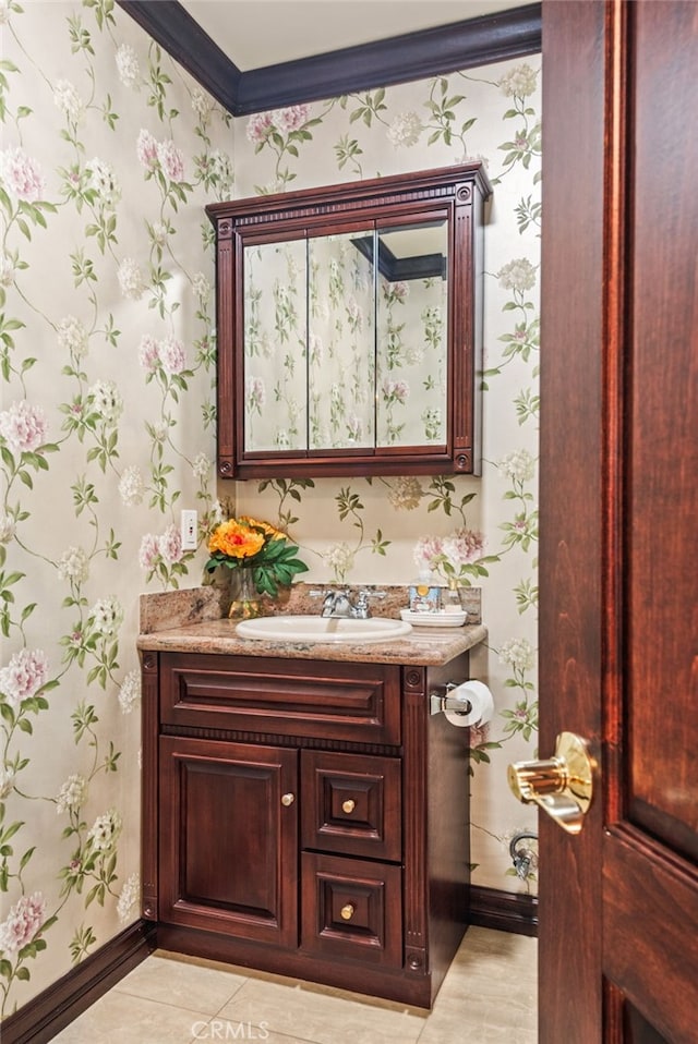 bathroom featuring wallpapered walls, vanity, crown molding, and baseboards