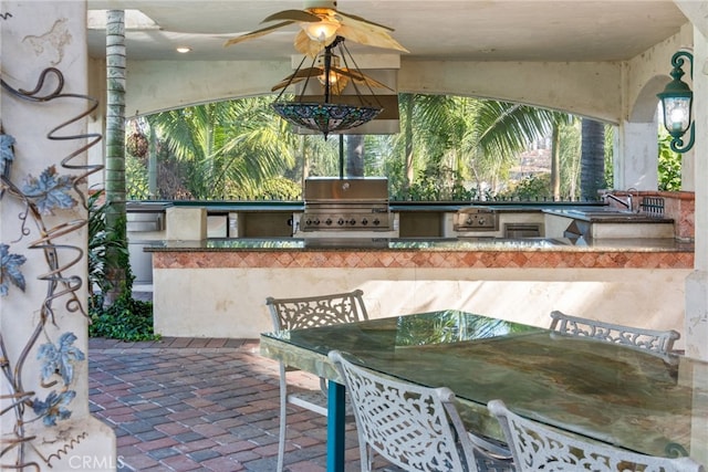 view of patio featuring grilling area, a ceiling fan, and exterior kitchen