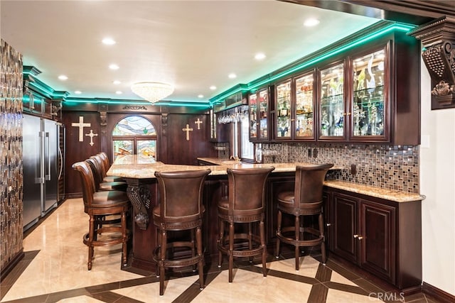 bar featuring decorative backsplash, indoor wet bar, high quality fridge, and recessed lighting