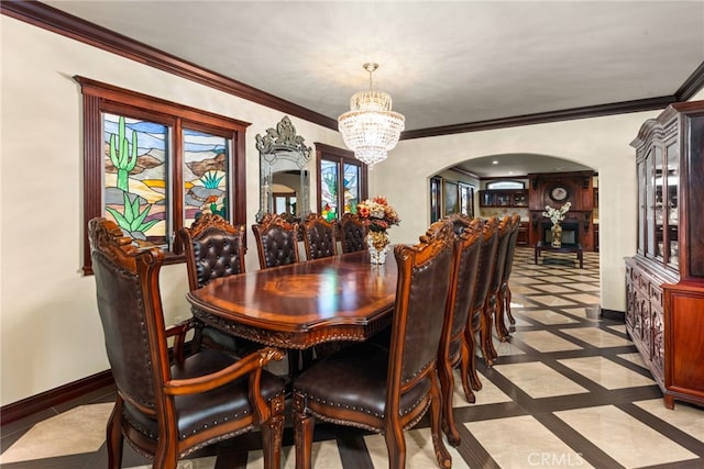 dining area with arched walkways, a chandelier, baseboards, and ornamental molding