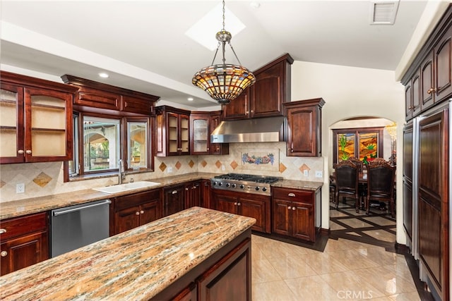 kitchen featuring a sink, under cabinet range hood, vaulted ceiling, decorative light fixtures, and appliances with stainless steel finishes