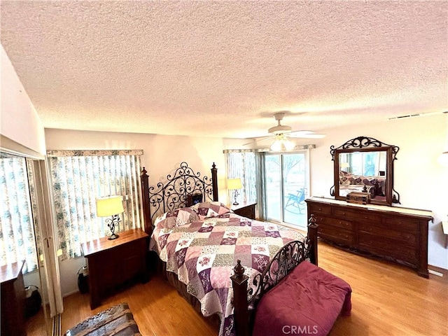 26221 Germantown Dr, Menifee, CA 92586 - bedroom with light wood-style floors, a textured ceiling, access to exterior, and ceiling fan
