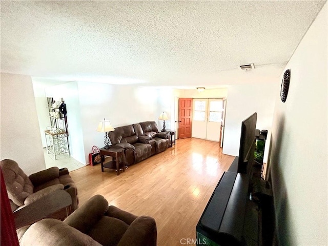 26221 Germantown Dr, Menifee, CA 92586 - living room featuring a textured ceiling, light wood-type flooring, and french doors
