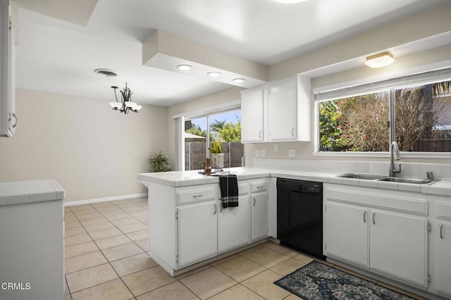 kitchen featuring a sink, dishwasher, tile countertops, a peninsula, and white cabinetry