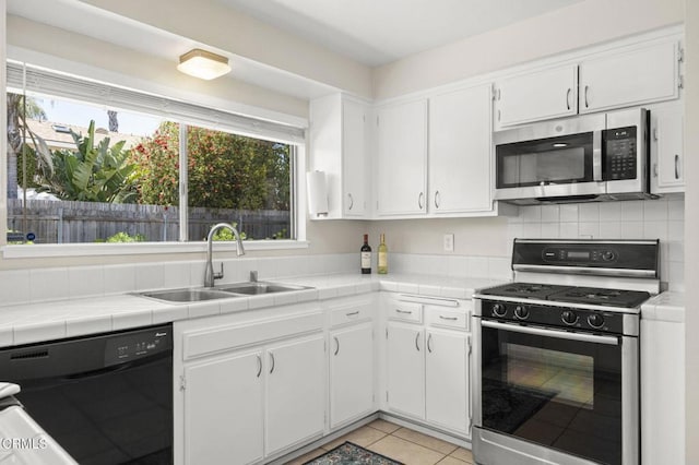 kitchen featuring white cabinets, a sink, gas stove, black dishwasher, and stainless steel microwave
