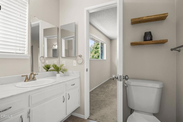 bathroom with vanity, baseboards, and toilet