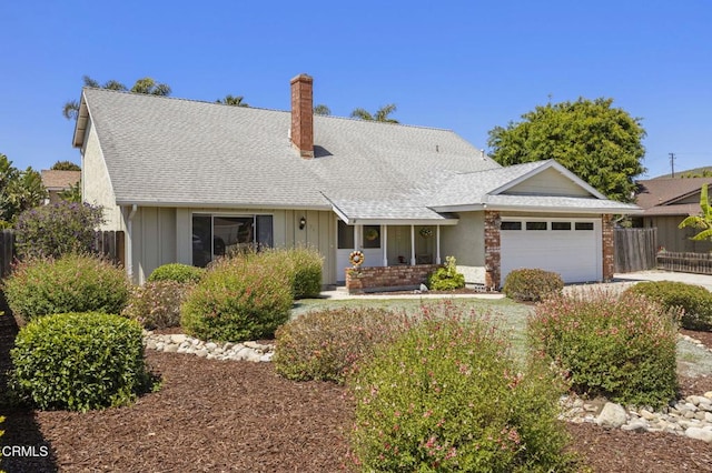 view of front of house featuring fence, roof with shingles, a chimney, board and batten siding, and an attached garage