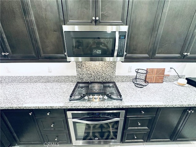 kitchen with appliances with stainless steel finishes and light stone counters