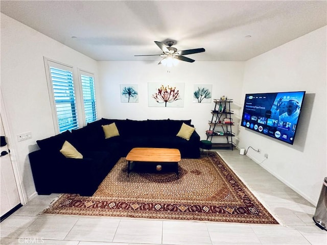 living room featuring baseboards and ceiling fan