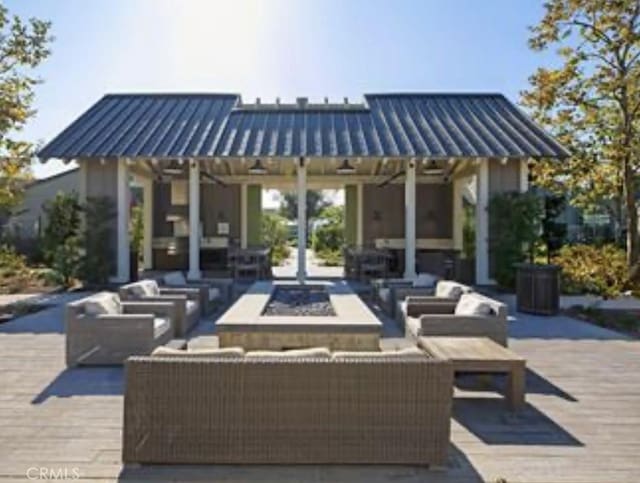 view of patio / terrace with an outbuilding and an outdoor living space with a fire pit