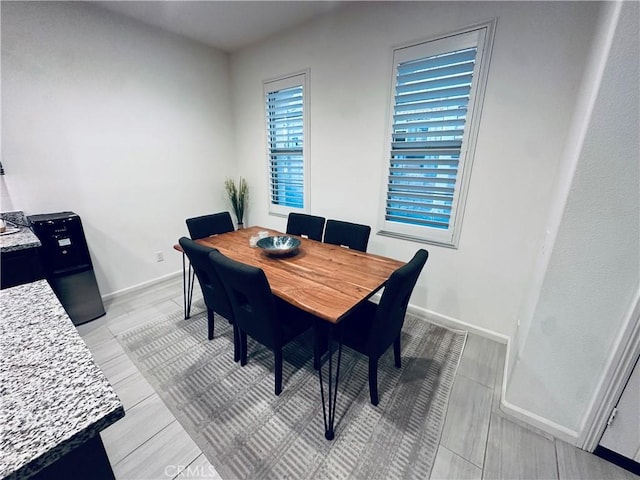 dining area with baseboards and light wood-style floors