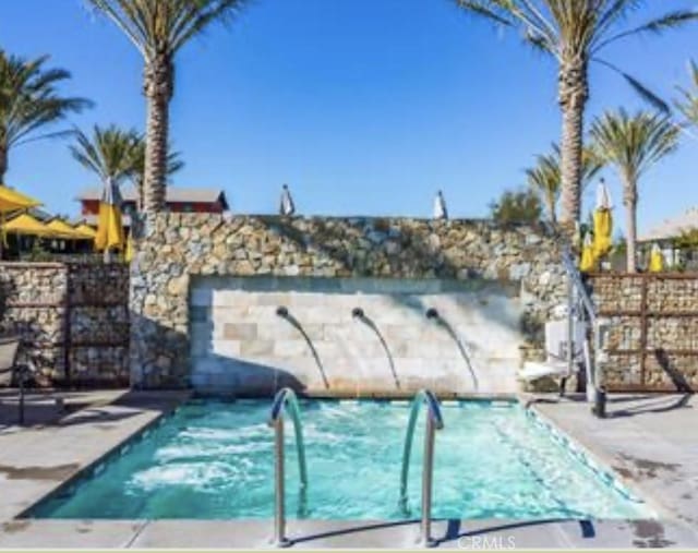 community pool with fence and a patio area