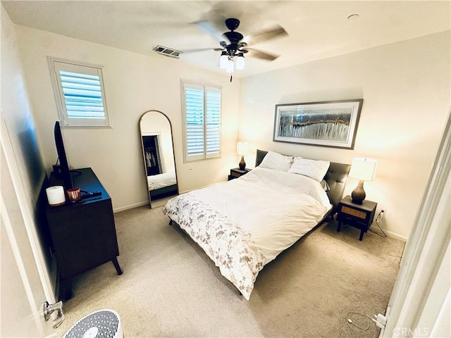 bedroom with light colored carpet, baseboards, multiple windows, and visible vents