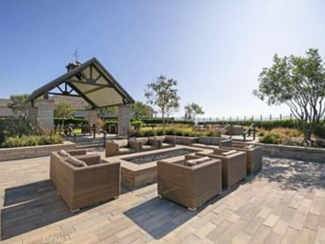 view of patio with an outdoor living space with a fire pit
