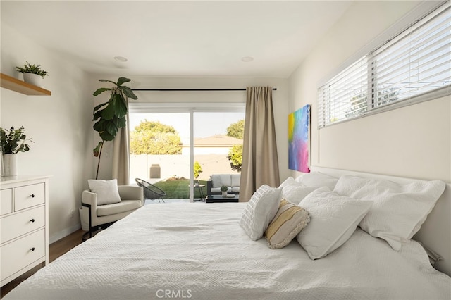 bedroom featuring wood finished floors, access to exterior, and multiple windows